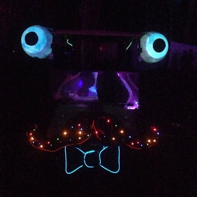 Zerble lit up at night at Bear Creek in 2014: glowing eyeballs, a mustache strung with colored lights, and a bow tie outlined in blue EL wire.