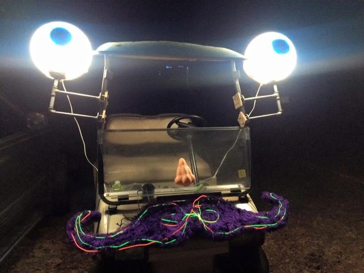 Zerble at night at SpringFest 2016, the eyeballs on their stalks blazing white and the purple mustache traced in glowing green and orange EL wire.