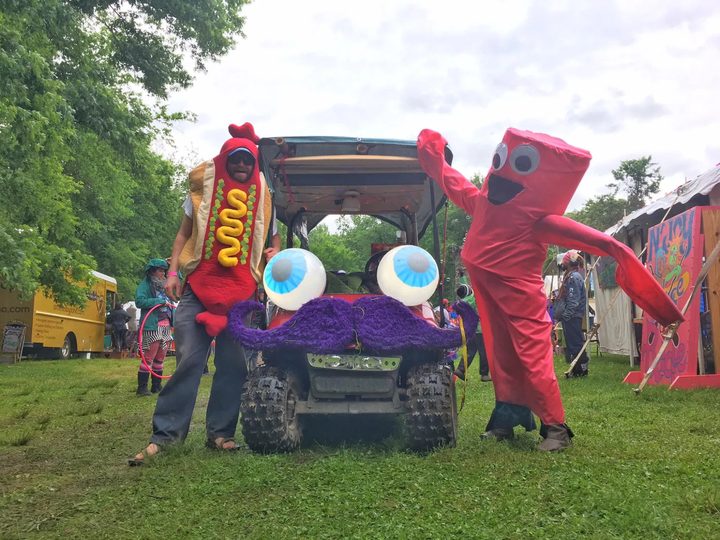 Locke in a hot dog costume and a friend in a red inflatable-tube-man costume pose on either side of Zerble at French Broad River Fest.
